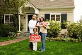 Family with sold home sign